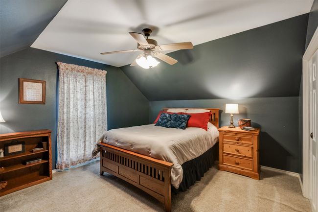 Carpeted bedroom with lofted ceiling, baseboards, and ceiling fan | Image 17
