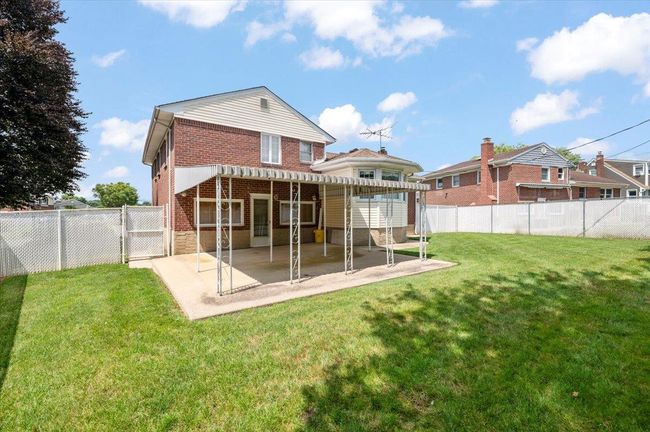 Back of house featuring brick siding, a patio area, a fenced backyard, and a gate | Image 26