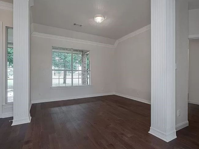 Unfurnished room featuring decorative columns, dark wood-style flooring, and ornamental molding | Image 20