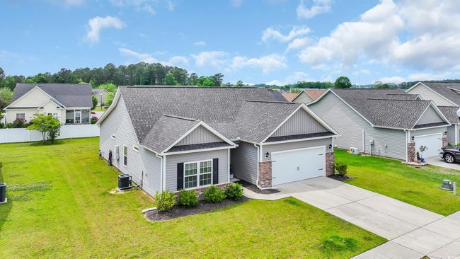View of front of house with roof with shingles, a front lawn, driveway, central AC, and an attached garage | Image 4