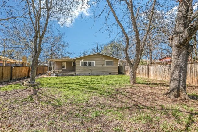 Back of property with crawl space, a fenced backyard, and a lawn | Image 13