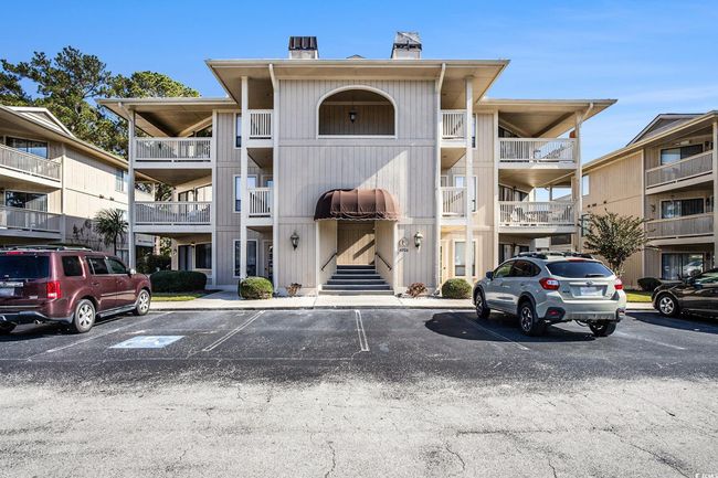 View of apartment building / complex featuring uncovered parking | Image 25