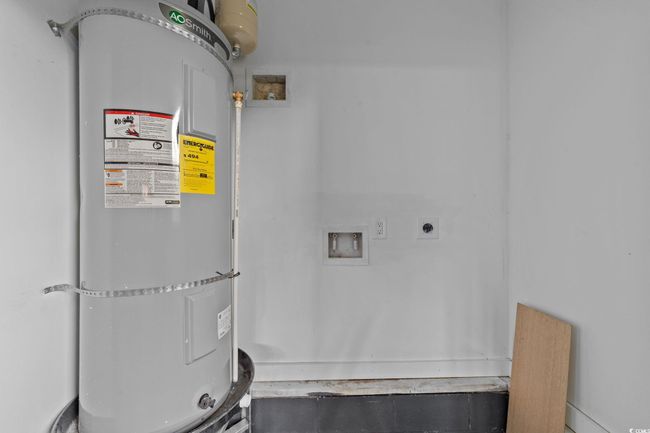 Washroom featuring hookup for an electric dryer, secured water heater, and washer hookup | Image 40