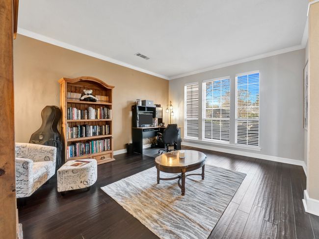 Sitting room with crown molding, baseboards, and wood finished floors | Image 10