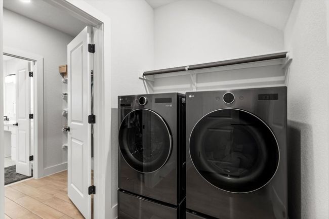 Laundry area with washing machine and clothes dryer and light wood finished floors | Image 16