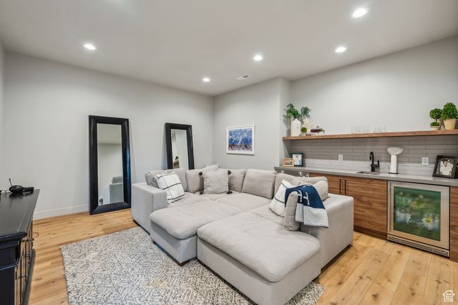 Living room featuring recessed lighting, light wood finished floors, wine cooler, visible vents, and indoor wet bar | Image 45