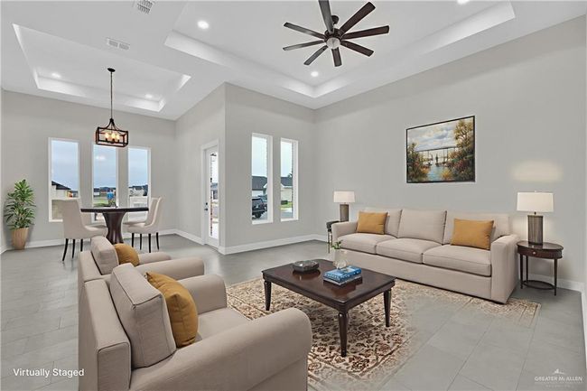 Living area with a raised ceiling, ceiling fan, plenty of natural light, baseboards, and recessed lighting | Image 4