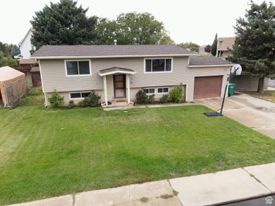 Bi-level home with a front yard and a garage | Image 1