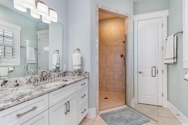 Bathroom featuring baseboards, vanity, a shower stall, and tile patterned floors | Image 21