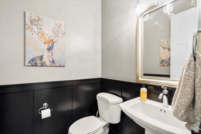 Bathroom with a sink, toilet, a decorative wall, and wainscoting | Image 22