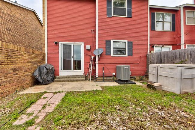 Rear view of house with central air condition unit, entry steps, and fence | Image 15