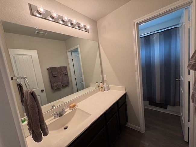Bathroom featuring wood finished floors, vanity, a shower with curtain, and baseboards | Image 12