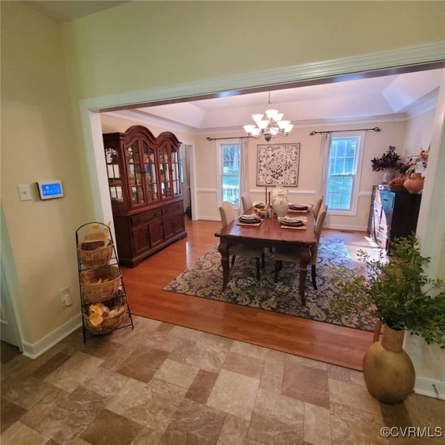 Dining room featuring a wealth of natural light, a tray ceiling, baseboards, and a notable chandelier | Image 13