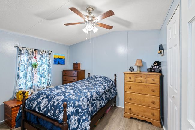 Bedroom with wood finished floors, vaulted ceiling, and a ceiling fan | Image 13