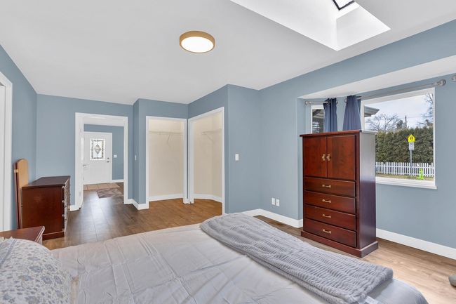 Bedroom with baseboards, a closet, wood finished floors, and a skylight | Image 12