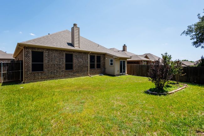 Back of property featuring brick siding, a chimney, and a shingled roof | Image 32