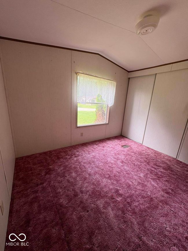 unfurnished bedroom with lofted ceiling and carpet | Image 17