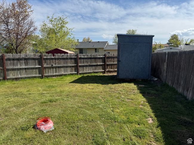 View of yard featuring a storage unit, an outbuilding, and a fenced backyard | Image 14