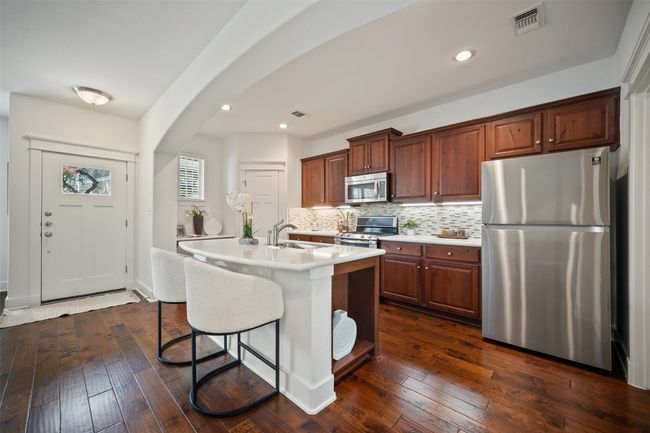 With stainless steel appliances, wood cabinetry, tile backsplash and a built-in breakfast bar in the center island, it’s ideal for everything from morning coffee to Sunday brunch | Image 13