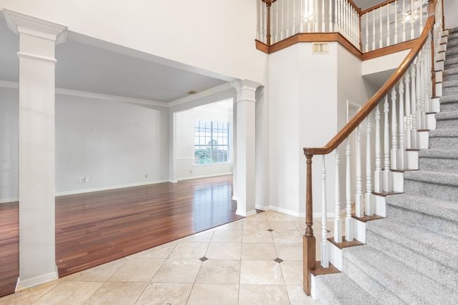 Foyer entrance featuring ornate columns, tile patterned floors, ornamental molding, stairway, and baseboards | Image 8