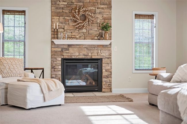 The stacked stone gas fireplace with floating mantel is the focal point of the family room. | Image 17