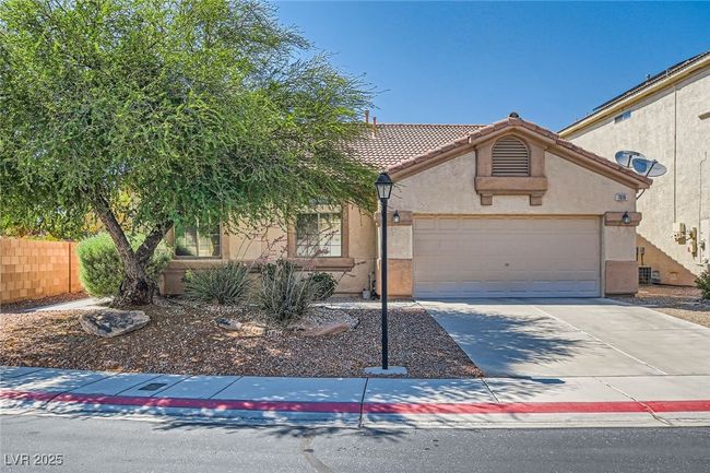 View of front of house featuring stucco siding, driveway, a tile roof, and a garage | Image 4