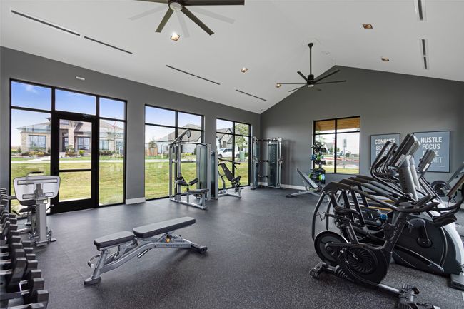 Exercise room featuring a ceiling fan and high vaulted ceiling | Image 39