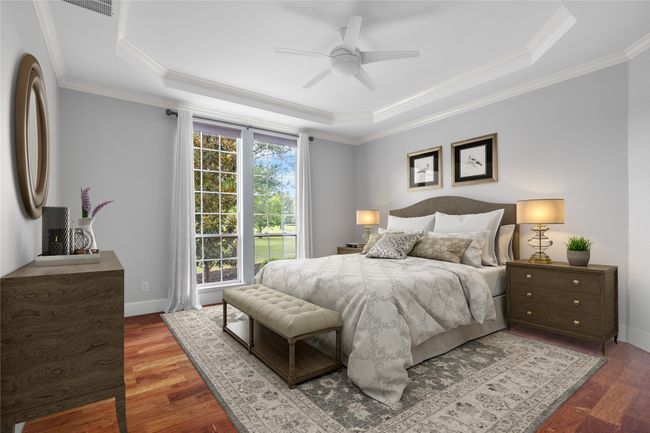 Bright and spacious primary suite with rich wood floors and abundant natural light from large windows. | Image 14