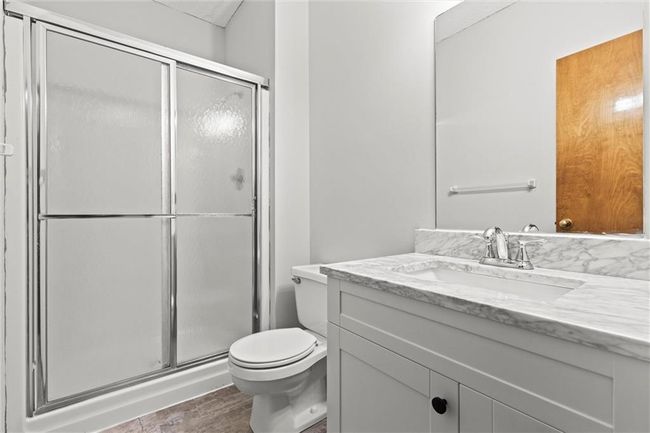 Bathroom with vanity, a shower with shower door, and toilet | Image 25