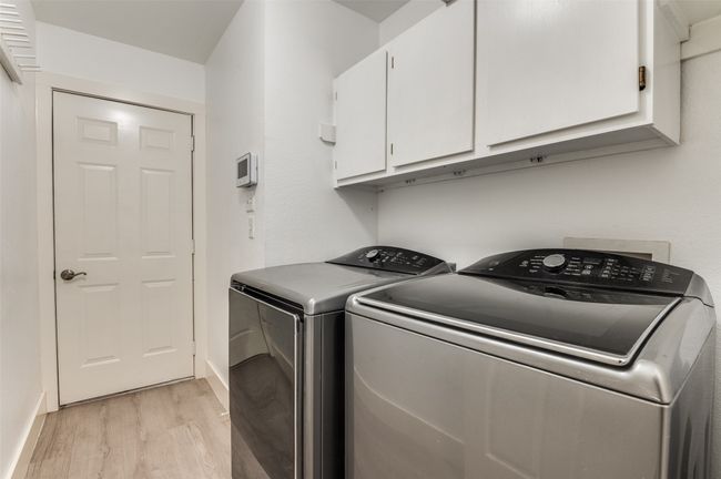 Washroom with cabinet space, light wood-type flooring, and washer and dryer | Image 12