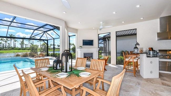 View of patio featuring outdoor dining area, a fireplace, an outdoor kitchen, and ceiling fan | Image 4