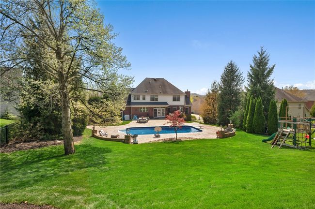 Private fenced in back yard with patio, outdoor kitchen, inground pool, and playground area. | Image 36