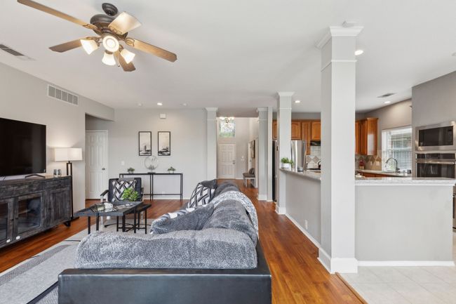 Living room featuring decorative columns, ceiling fan, light wood-style floors, and recessed lighting | Image 15