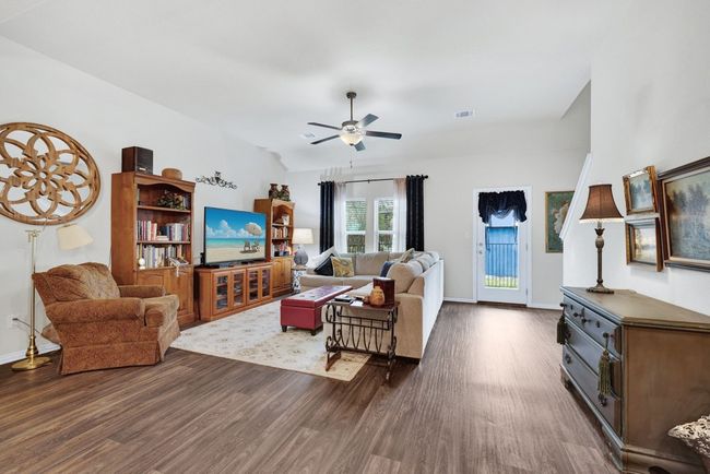 Living area featuring baseboards, dark wood-style flooring, ceiling fan, and visible vents | Image 12
