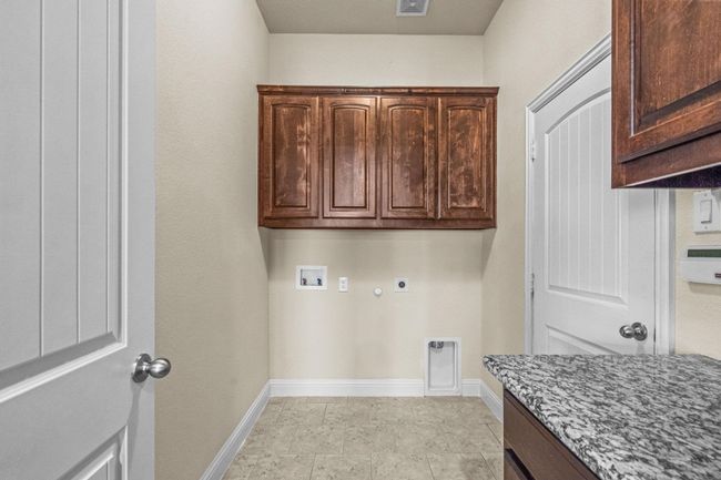 Washroom featuring cabinet space, electric dryer hookup, washer hookup, baseboards, and gas dryer hookup | Image 13
