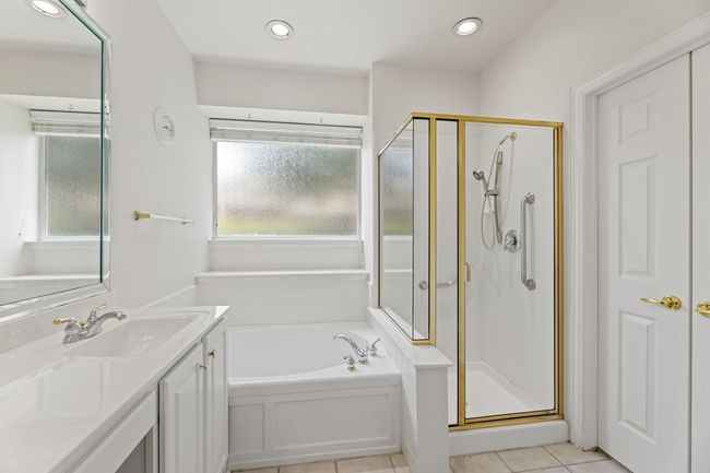 Full bath with a stall shower, a bath, vanity, tile patterned floors, and recessed lighting | Image 29