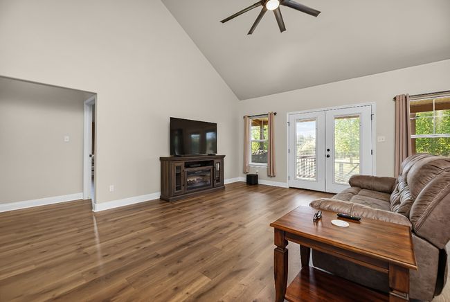 Living area featuring dark wood-type flooring, french doors, a ceiling fan, and a healthy amount of sunlight | Image 7