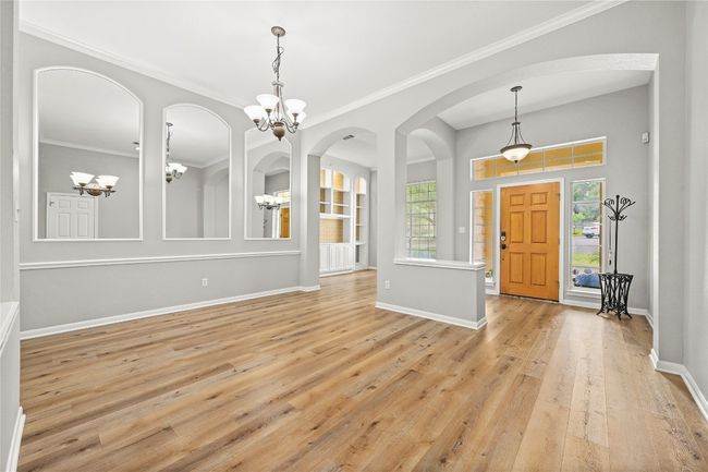 Foyer with a wealth of natural light, light wood-style flooring, a notable chandelier, and baseboards | Image 4