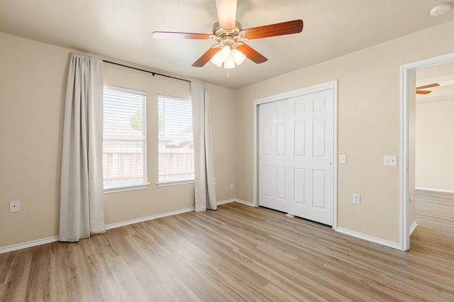 Unfurnished bedroom featuring light wood-style floors, ceiling fan, and a closet | Image 16