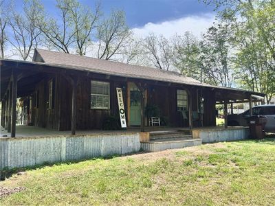 View of front of property featuring a front lawn, a porch, and a carport | Image 1