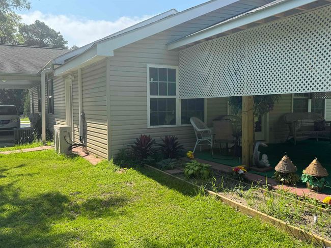 View of side of property featuring a lawn and ac unit | Image 23