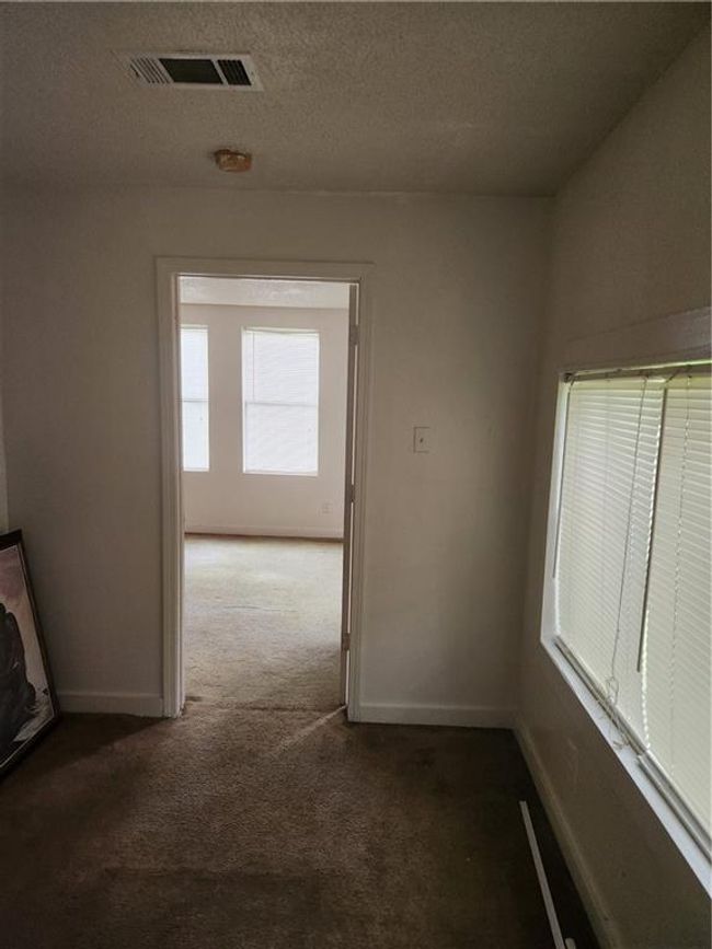 Corridor featuring carpet flooring and a textured ceiling | Image 21