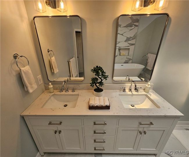 Ensuite Bathroom featuring quartz finish floors, double vanity, a freestanding tub, a textured ceiling, and a shower & separate lavatory/closet | Image 33