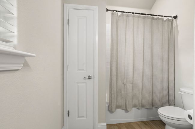 Bathroom featuring wood finished floors and shower / bath combination with curtain | Image 14