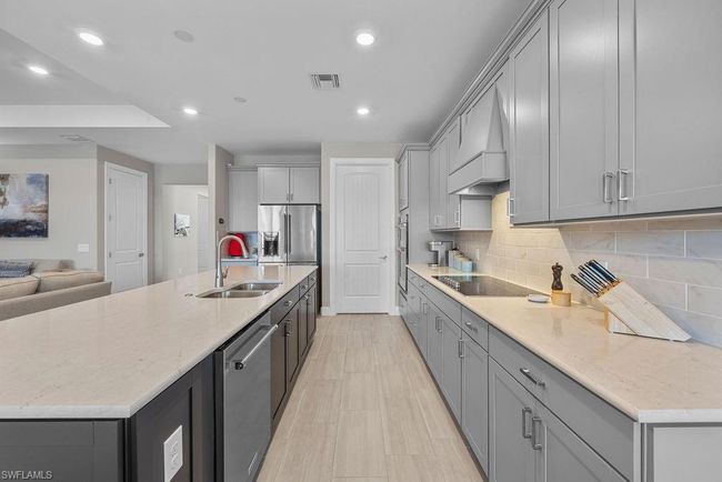 Kitchen with visible vents, gray cabinets, a sink, stainless steel appliances, and custom exhaust hood | Image 29