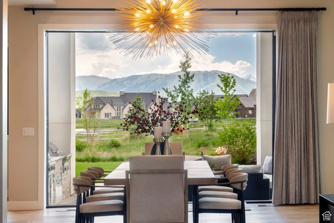Dining area featuring a mountain view, wood finished floors, and a chandelier | Image 11