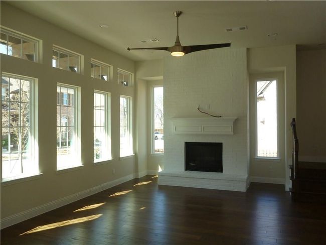 Unfurnished living room with healthy amount of natural light, dark wood finished floors, baseboards, and ceiling fan | Image 10