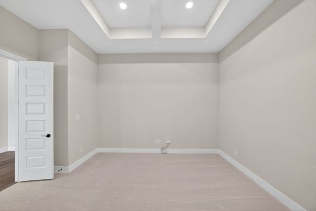 Empty room featuring light colored carpet and a tray ceiling | Image 17