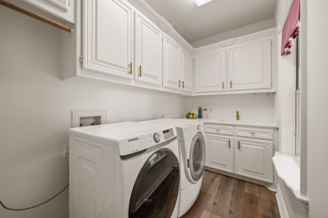 Laundry area featuring hardwood / wood-style floors, a sink, and cabinet space | Image 30