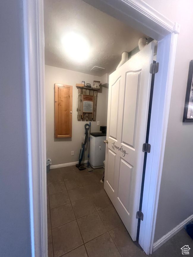Hall featuring dark tile patterned floors and baseboards | Image 41